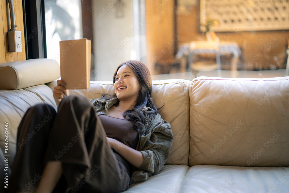 Obraz premium Woman relaxing at home, enjoying leisure time reading