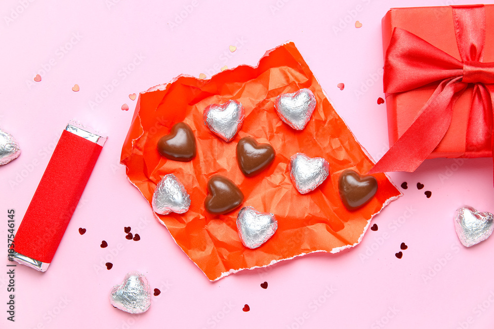 Fototapeta premium Chocolate bar and candies with gift box on pink background. Valentine's Day celebration