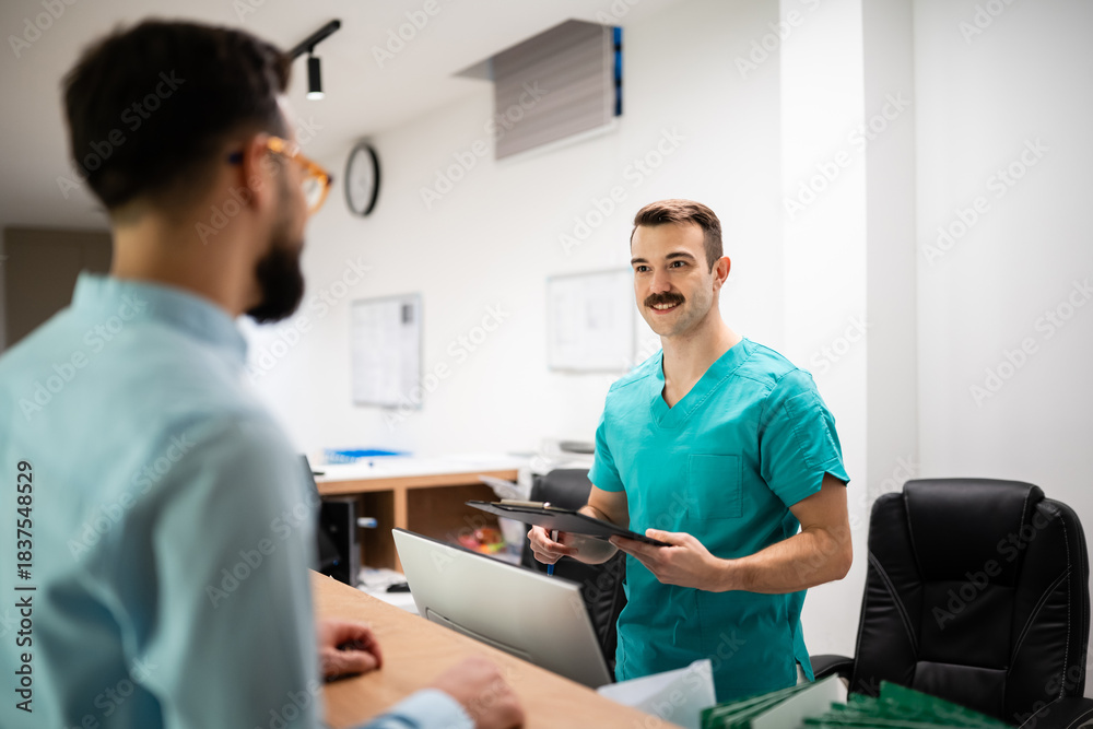 Fototapeta premium Medical receptionist checking in patient at clinic desk