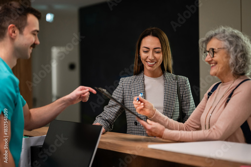 Slika na platnu Patients checking in at clinic reception desk