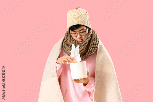 Ill Asian man with tissue b...