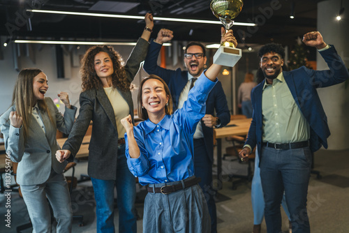 Obraz na plátne Diverse business team celebrating achievement receiving golden trophy award