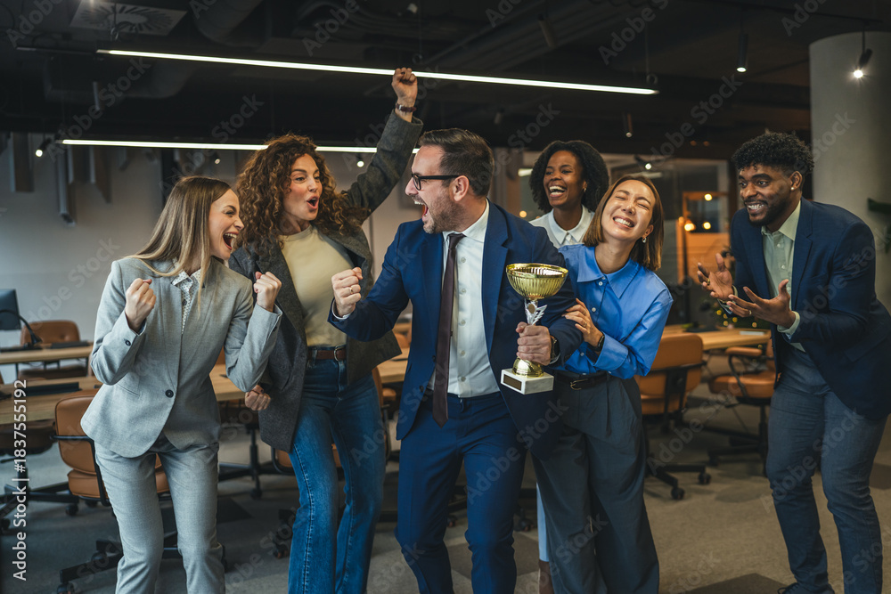 Obraz premium Diverse business team celebrating achievement and success holding trophy