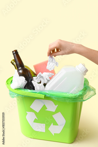 Woman throwing garbage into...