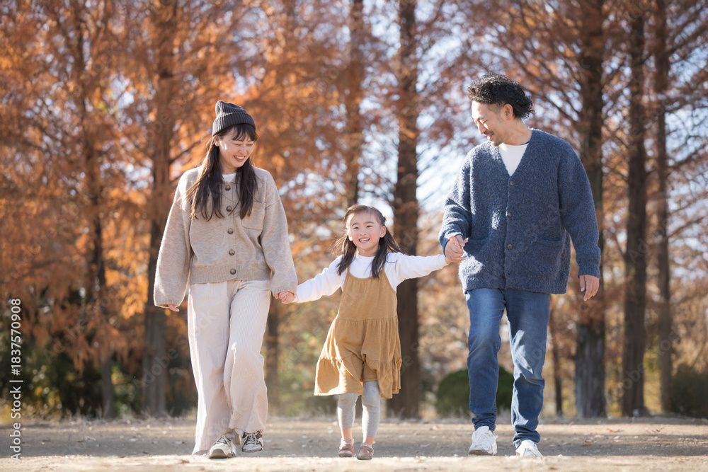Fototapeta premium 秋の公園で遊ぶ家族 お出かけやレジャーのイメージの手を繋ぐ