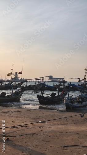 sunset atmosphere on a beach full of fishing boats