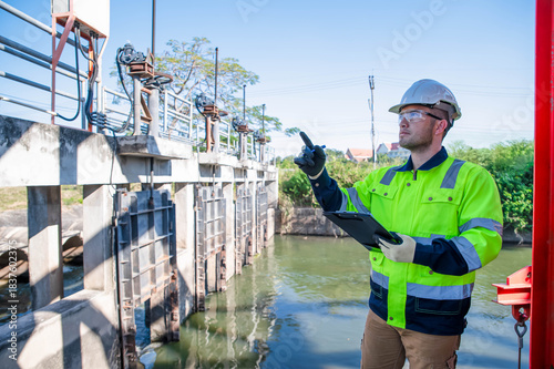 A specialist engineer is testing the water gate opening and closing system of a dam.