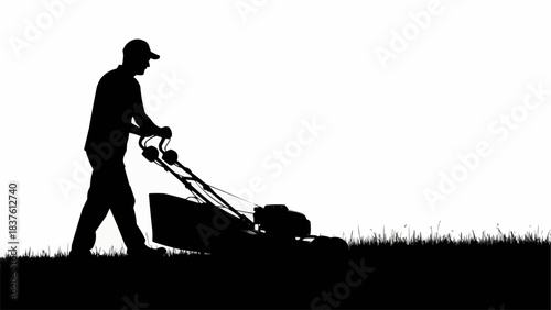 Silhouette of a man mowing the lawn with a push mower.