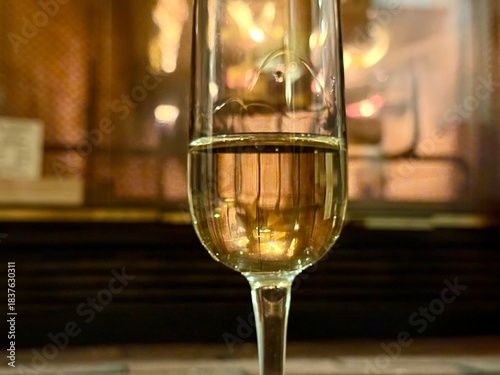 Close-up of champagne glass with fireplace behind