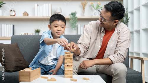 Family Bonding. Father and son playing Jenga together at home.