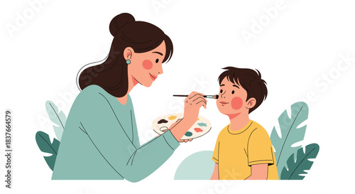 Loving mother gently applies colorful face paint with a small brush to her happy young son's cheek for a fun party activity.