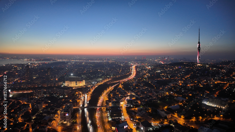 Fototapeta premium City skyline at sunset with lights and tall tower visible in istanbul 