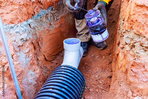 Wallpaper Mural Worker applies sealant to joint while installing drainage system in construction site Torontodigital.ca