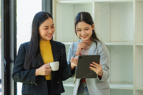 Portrait of two young businesswomen having a meeting or presentation and seminar standing in the office. Portrait of a young businesswoman talking.