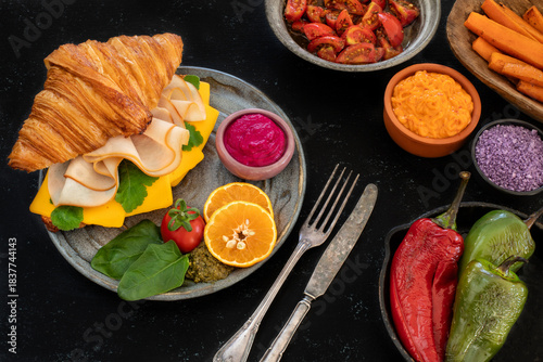 Croissant sandwich filled with ham, bacon, cheese and salad.  crowich