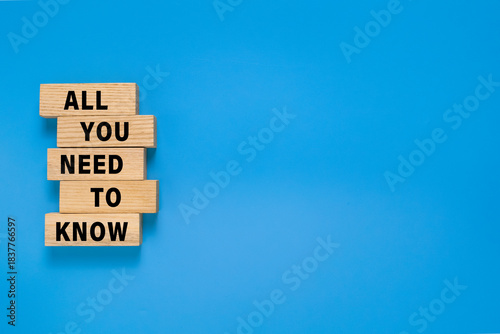 all you need to know words text symbol on wooden blocks. isolated on blue background