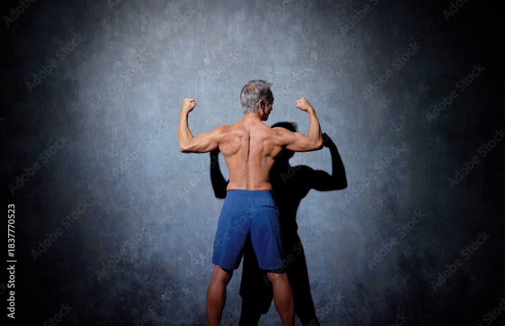 Obraz premium ポーズをとる筋肉のあるシニアの男性 後ろ姿