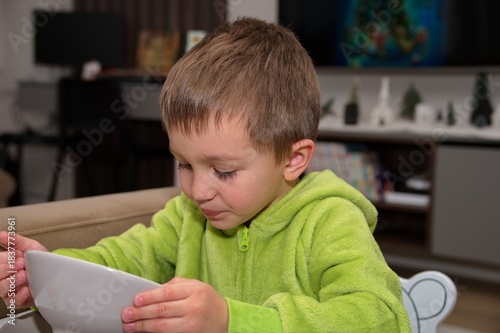 Little boy sitting at the table and eating soup