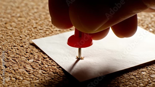 Hand Pinning a Note With Red Thumbtack to Cork Board