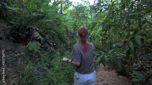 Tracking Shot of Young Woman Walking Away in Lush Overgrown Woods