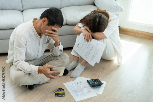 Stressed and headache asian couple with large bills or invoices no money to pay to expenses and business problem. shortage, Financial problems, mortgage, loan, bankruptcy, bankrupt, poor