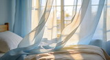 Fresh morning breeze blowing sheer blue curtains at open bedroom window with warm sunlight on white bed