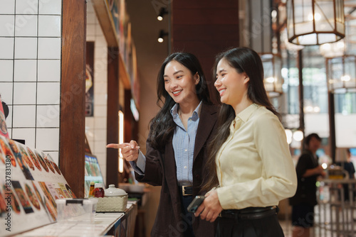 Cuadro en lienzo Two young women ordering food at restaurant counter