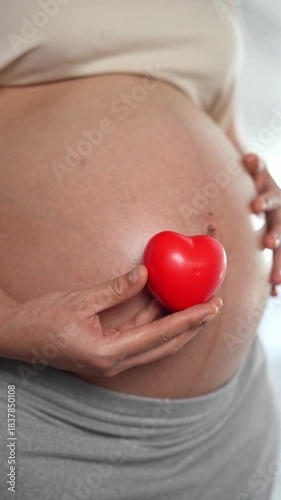 Wallpaper Mural Happy pregnant woman or mother touching baby in belly and hold red heart with love at home. Health care, Prenatal preparation, Maternity, Pregnancy, and motherhood concept Torontodigital.ca