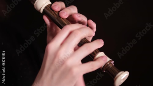 Woman playing a recorder. Hands playing a wooden wind instrument. Music performance and skill concept for musical education.
