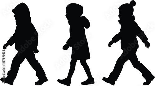 silhouettes of kids walking wearing winter dress
