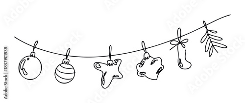 Hand drawn Christmas ornaments and sprig of greenery hanging on a festive string for holiday celebration and New Year decoration concepts.