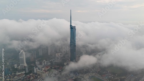 Aerial view time lapse 4k video of Kuala Lumpur city center view during dawn sunrise overlooking the city skyline in Federal Territory, Malaysia with dramatic low cloud rolling.  