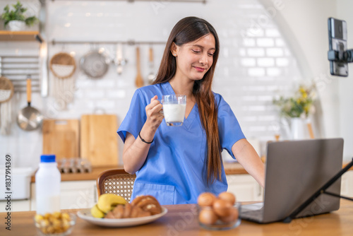Woman nutritionist healthy food content creator live streaming with breakfast, milk, banana, bread and egg in kitchen, vlog, wellness, healthy cooking high protein food content for social media