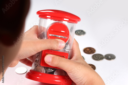 貯金箱を持つ子どもの手