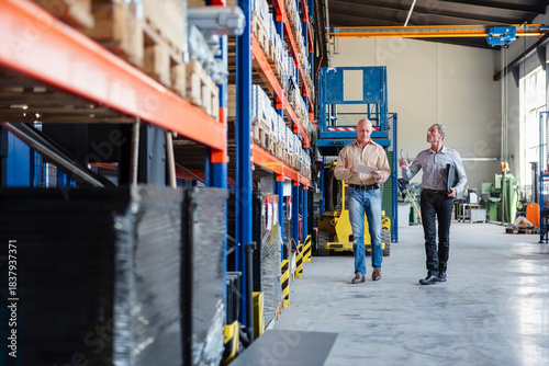 Employees discussing in a production hall at a warehouse facility