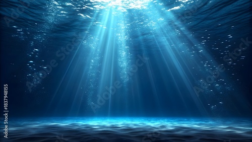 Stunning underwater sun rays pierce deep blue ocean illuminating sandy seabed with rising air bubbles