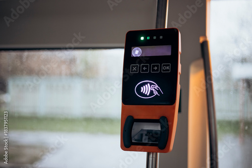 Tram with validator for self-payment. Fare control without a conductor. Public city passenger transport. Payment terminal in the bus, non-cash payment for travel in public transport. Copy space.