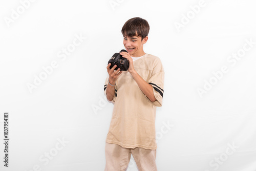 young photographer casual dressed Generation Z white male model fun teenage boy photo with DSLR camera. happy smile expressing joy in positive entertaining way in plain background studio setting