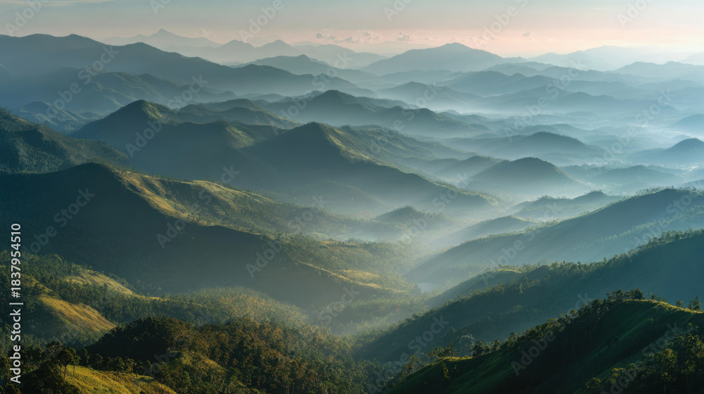 Fototapeta premium misty mountain range at sunrise with layers of peaks and valleys