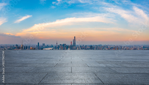 Empty square floor and city skyline with modern commercial buildings at sunset in Shanghai