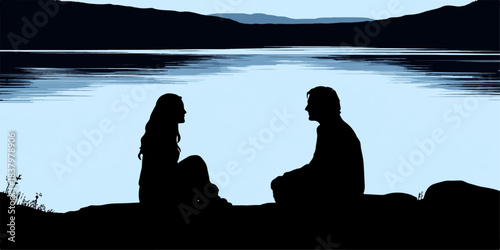 Couple silhouetted against a serene lake and distant mountains at dusk