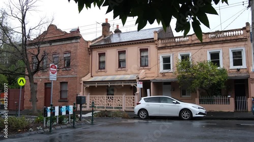 Traditional Victorian terrace houses along a quiet inner suburban street with parked cars in Melbourne, Australia. Concept of inner city living. Heritage residential architecture