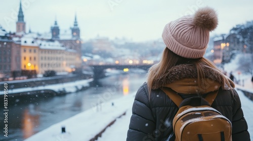 Traveler exploring a snowy cityscape by the river in winter
