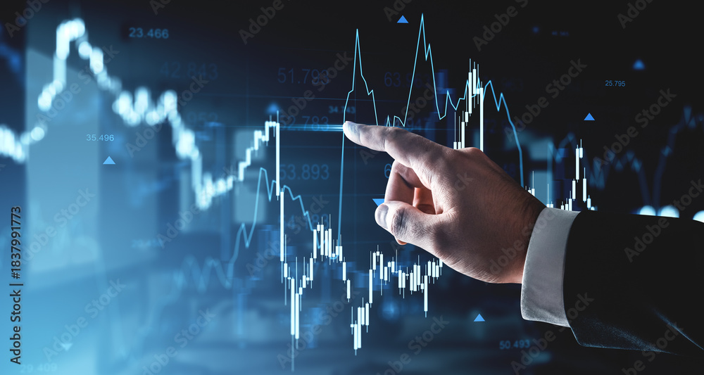 Naklejka premium Business hand pointing at rising financial chart with blue glowing lines and forex data on futuristic digital interface background in trading concept.