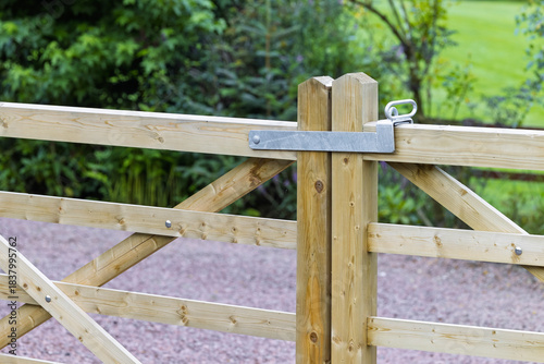 Photos Closed wooden driveway gate with a metal latch and timber posts