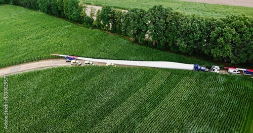 Aerial view of a heavy transport of a wind turbine blade to the construction site of a wind power plant, logistics, energy transition