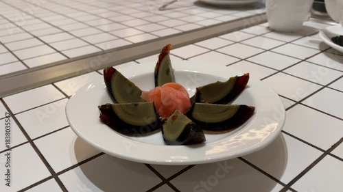 4k video footage of Century egg cut into six pieces and served on a white plate on a dining table.