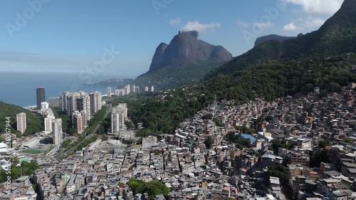 Aerial view of Rio de Janeiro, Brazil, flying over Favela da Rocinha toward Pedra da Gavea on a sunny day.