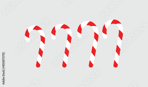 Four candy canes with red stripes dripping on a gray background