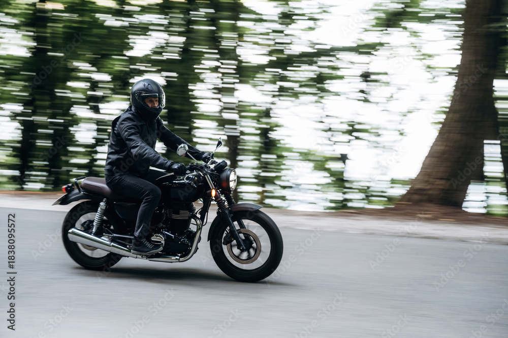 Fototapeta premium Driving fast. Man in leather clothes on motorcycle is on the road